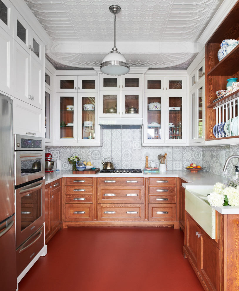 Idéer för att renovera ett avskilt, mellanstort eklektiskt vit vitt u-kök, med en rustik diskho, skåp i shakerstil, skåp i mellenmörkt trä, grått stänkskydd, stänkskydd i keramik, rostfria vitvaror, rött golv, bänkskiva i koppar och betonggolv