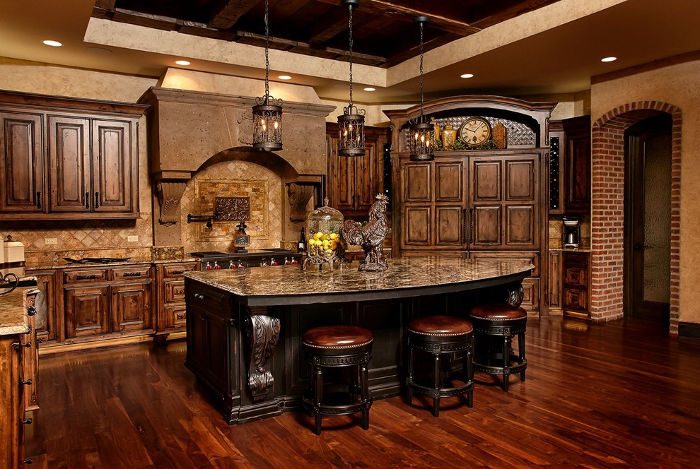 Rustik inredning av ett l-kök, med luckor med upphöjd panel, skåp i mörkt trä, granitbänkskiva, brunt stänkskydd, rostfria vitvaror, mörkt trägolv och en köksö