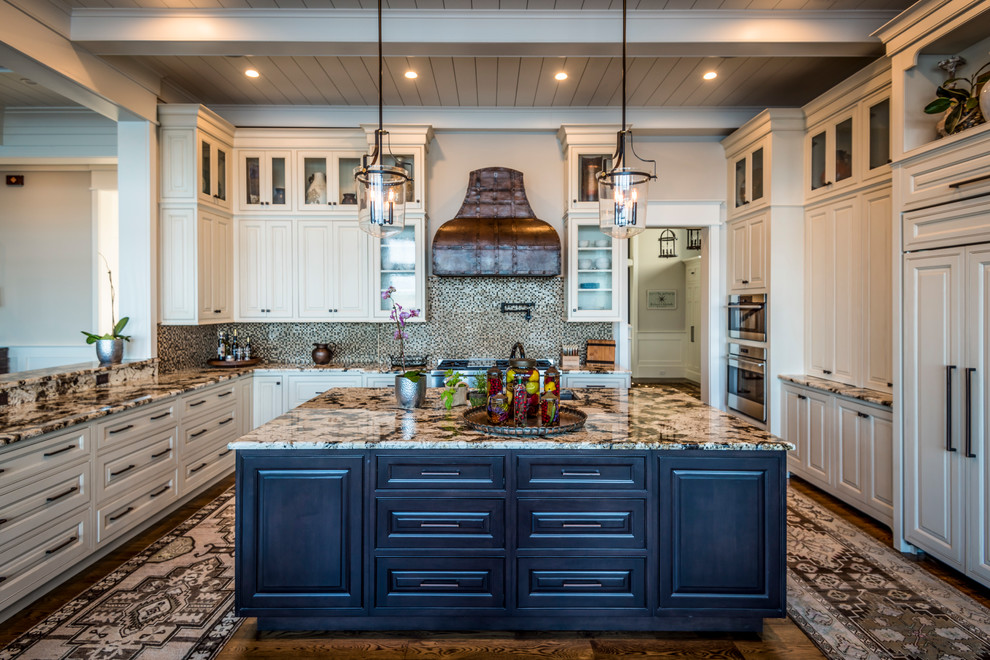Example of a large classic u-shaped brown floor and medium tone wood floor eat-in kitchen design in Charleston with an undermount sink, glass-front cabinets, white cabinets, granite countertops, brown backsplash, mosaic tile backsplash, stainless steel appliances and an island