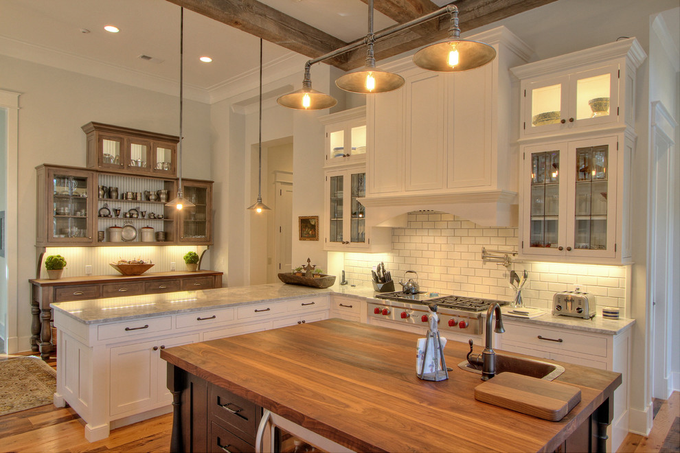 Klassische Küche mit Schrankfronten im Shaker-Stil, weißen Schränken, Küchenrückwand in Weiß, Rückwand aus Metrofliesen, braunem Holzboden und Kücheninsel in Atlanta