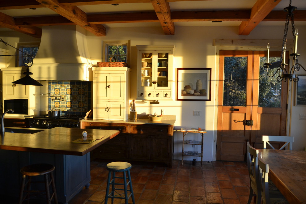 Aménagement d'une grande cuisine américaine méditerranéenne avec des portes de placard beiges, un plan de travail en bois, une crédence en mosaïque et îlot.