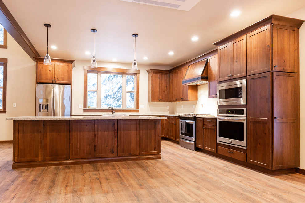 Foto på ett stort rustikt kök och matrum, med en rustik diskho, skåp i shakerstil, rostfria vitvaror och en köksö