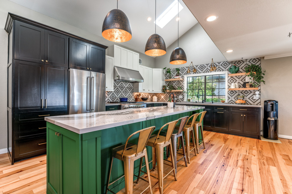 Kitchen - eclectic l-shaped medium tone wood floor, brown floor and vaulted ceiling kitchen idea in Los Angeles with shaker cabinets, black cabinets, multicolored backsplash, stainless steel appliances, an island and white countertops