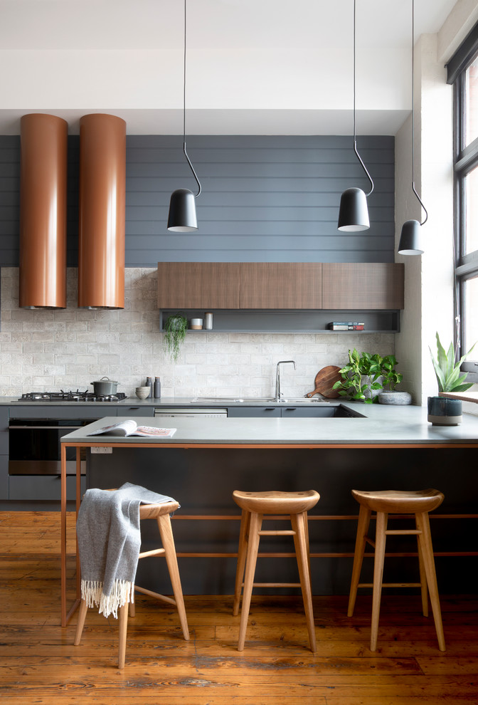 Bild på ett mellanstort funkis grå grått kök, med en dubbel diskho, släta luckor, grå skåp, bänkskiva i kvarts, grått stänkskydd, stänkskydd i keramik, rostfria vitvaror, mellanmörkt trägolv, en köksö och brunt golv