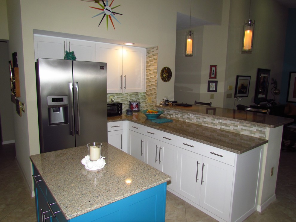 Exempel på ett avskilt, mellanstort klassiskt l-kök, med en dubbel diskho, skåp i shakerstil, vita skåp, granitbänkskiva, flerfärgad stänkskydd, stänkskydd i mosaik, rostfria vitvaror, klinkergolv i keramik, en köksö och beiget golv