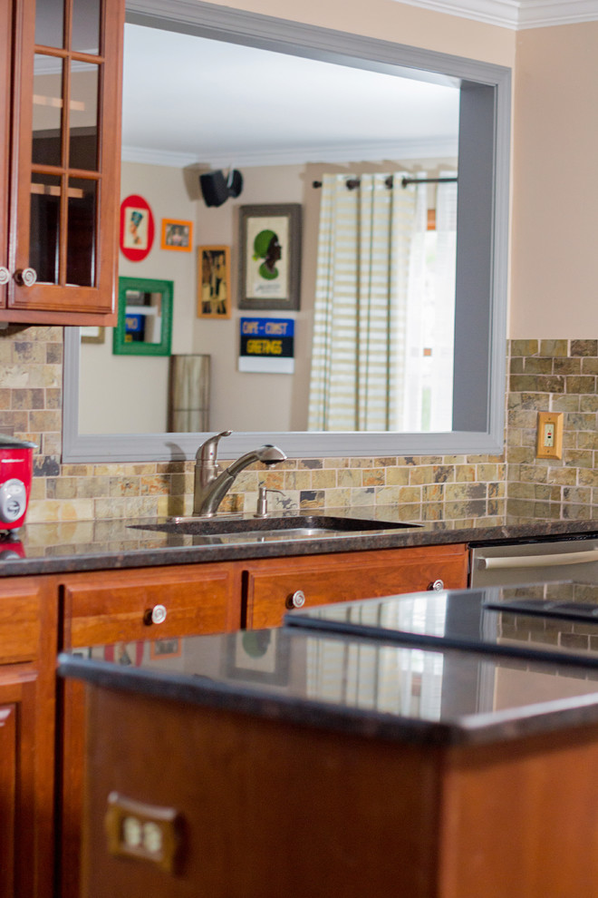 Foto di una cucina chic con ante di vetro, top in granito, paraspruzzi marrone, elettrodomestici in acciaio inossidabile e ante in legno scuro