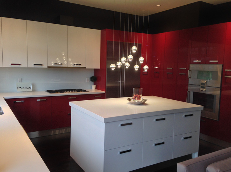 Example of a huge minimalist l-shaped dark wood floor open concept kitchen design in Vancouver with a single-bowl sink, glass-front cabinets, red cabinets, laminate countertops, white backsplash, glass tile backsplash, stainless steel appliances and an island