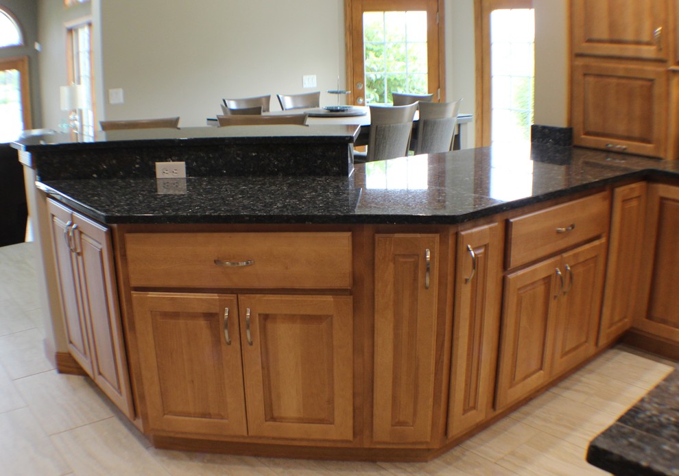 Exempel på ett mellanstort klassiskt kök, med en undermonterad diskho, luckor med upphöjd panel, skåp i ljust trä, granitbänkskiva, rostfria vitvaror, klinkergolv i keramik och en köksö