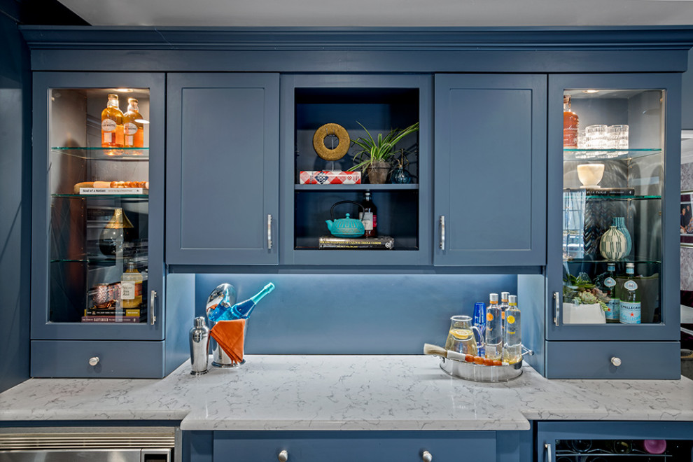 Expansive eclectic l-shaped kitchen/diner in Philadelphia with a single-bowl sink, flat-panel cabinets, blue cabinets, marble worktops, blue splashback, glass tiled splashback, stainless steel appliances, dark hardwood flooring, an island, brown floors and white worktops.
