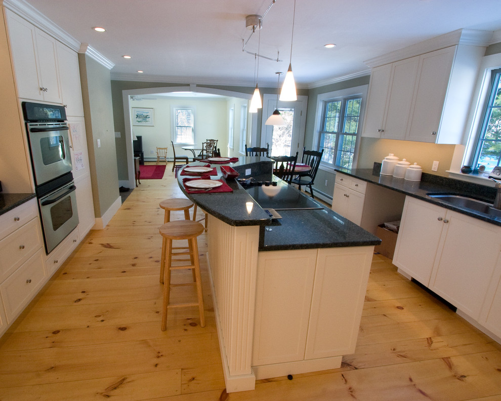 Foto de cocina comedor de estilo de casa de campo con fregadero bajoencimera, puertas de armario blancas y barras de cocina