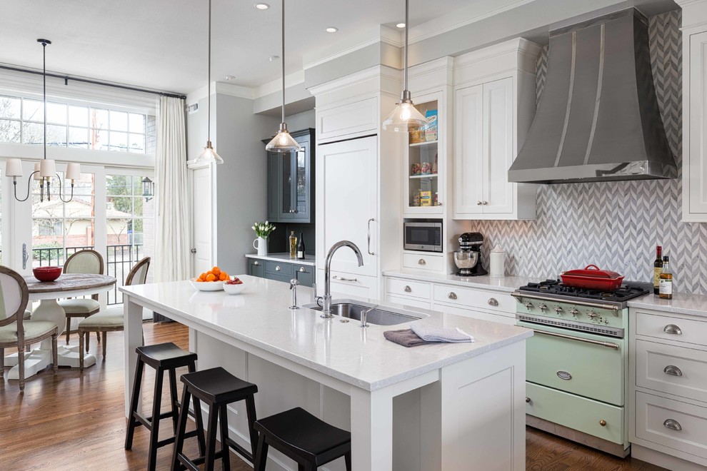 Open concept kitchen - large transitional l-shaped dark wood floor and brown floor open concept kitchen idea in Portland with an undermount sink, recessed-panel cabinets, white cabinets, gray backsplash, stone tile backsplash, paneled appliances, an island, quartz countertops and white countertops