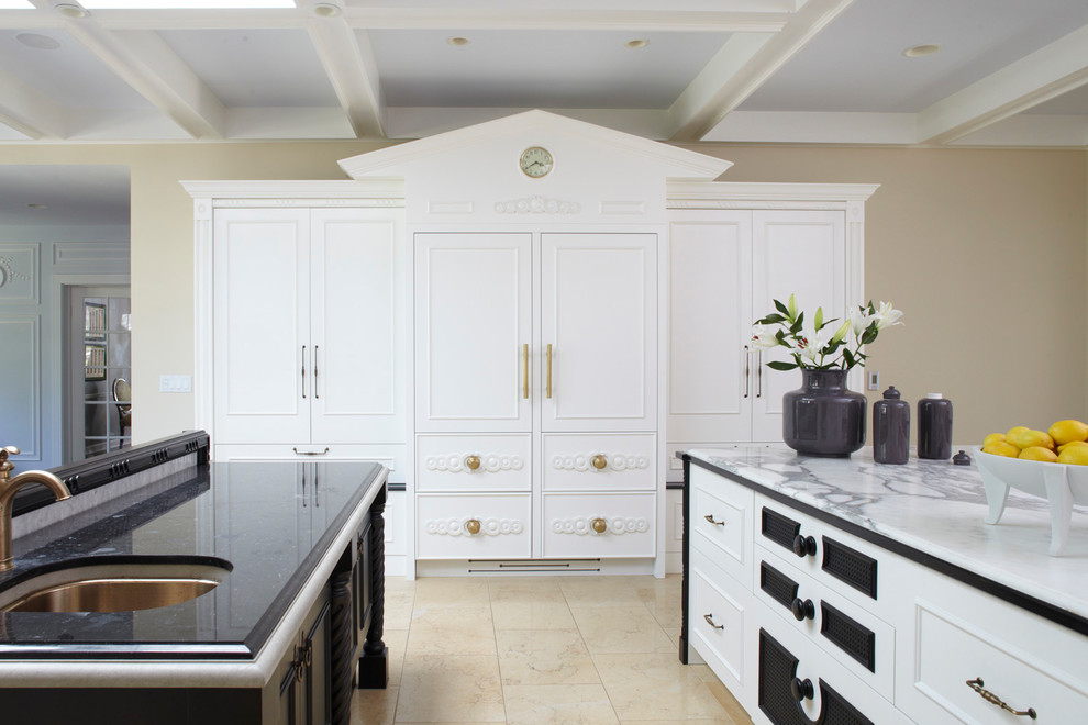 Modern inredning av ett avskilt kök, med en dubbel diskho, luckor med profilerade fronter, vita skåp, marmorbänkskiva, gult stänkskydd, stänkskydd i keramik, integrerade vitvaror, kalkstensgolv och flera köksöar