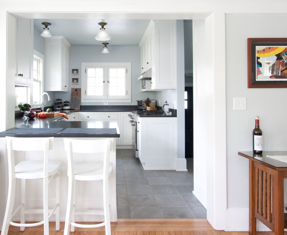 Klassisk inredning av ett avskilt, mellanstort l-kök, med en undermonterad diskho, skåp i shakerstil, vita skåp, bänkskiva i koppar, rostfria vitvaror, skiffergolv, en halv köksö och grått golv
