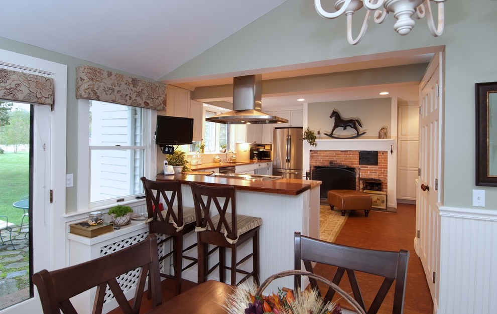 Eat-in kitchen - mid-sized contemporary u-shaped cork floor eat-in kitchen idea in Providence with an undermount sink, raised-panel cabinets, white cabinets, solid surface countertops, white backsplash, stainless steel appliances and a peninsula
