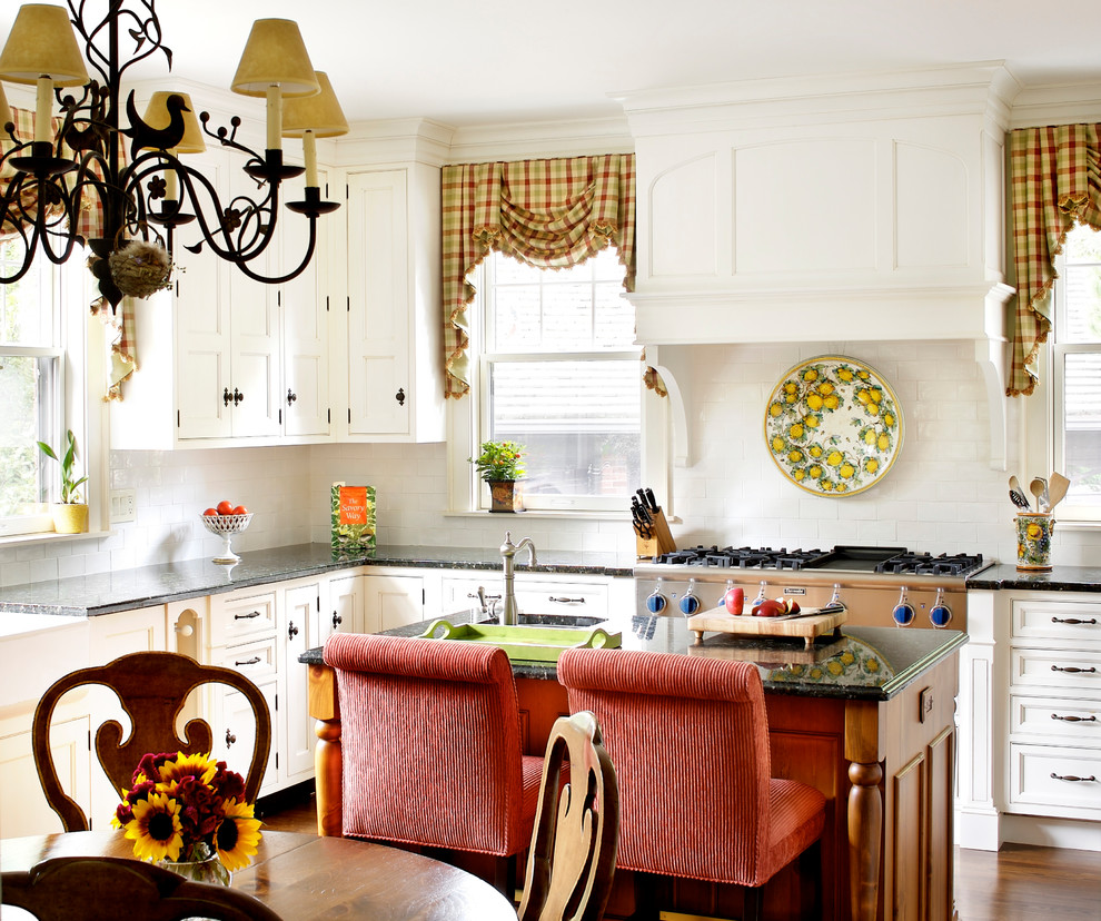 Foto på ett vintage kök och matrum, med en rustik diskho, luckor med infälld panel, vita skåp, vitt stänkskydd, stänkskydd i tunnelbanekakel, rostfria vitvaror och en köksö