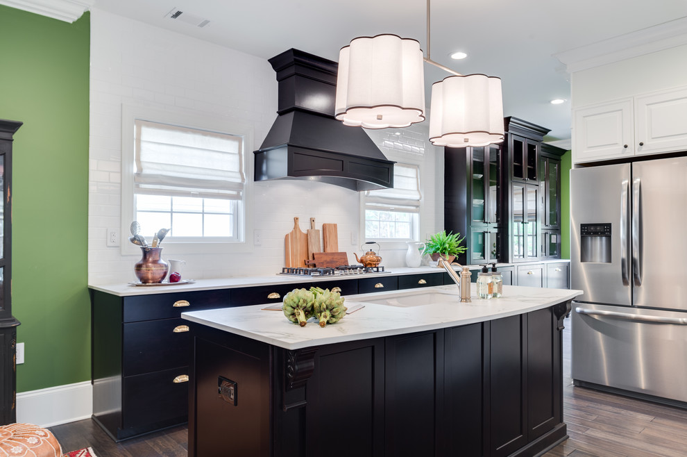 Large trendy u-shaped dark wood floor and brown floor eat-in kitchen photo in Atlanta with dark wood cabinets, marble countertops, white backsplash, flat-panel cabinets, subway tile backsplash, stainless steel appliances, an island and an undermount sink