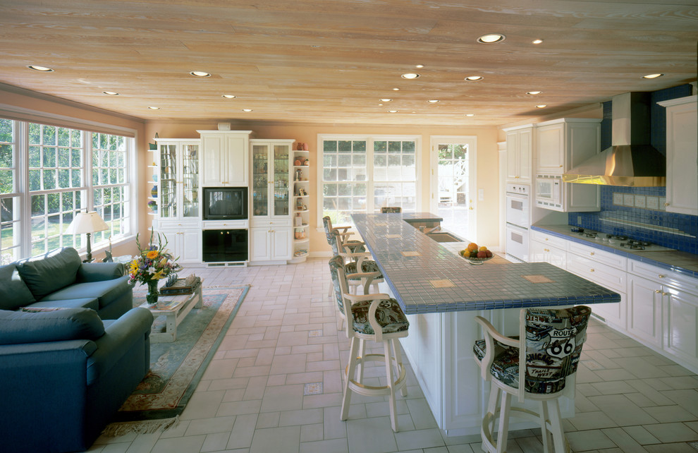 Large elegant single-wall eat-in kitchen photo in Los Angeles with flat-panel cabinets, white cabinets, tile countertops, blue backsplash and an island