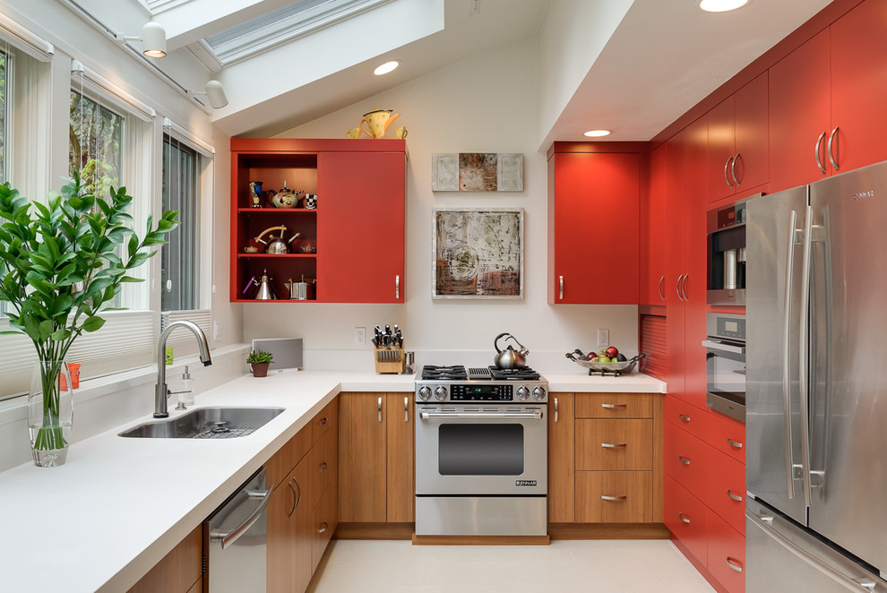 Moderne Küche in L-Form mit Unterbauwaschbecken, flächenbündigen Schrankfronten, roten Schränken und Küchengeräten aus Edelstahl in Portland