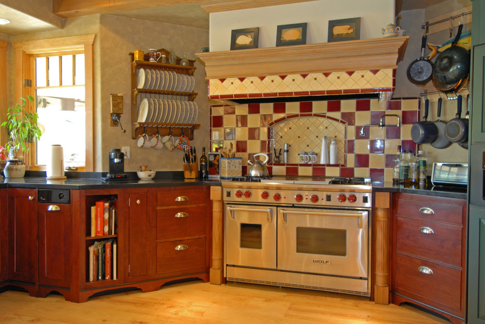 This is an example of a large bohemian u-shaped open plan kitchen in San Luis Obispo with red cabinets, granite worktops, multi-coloured splashback, ceramic splashback and light hardwood flooring.