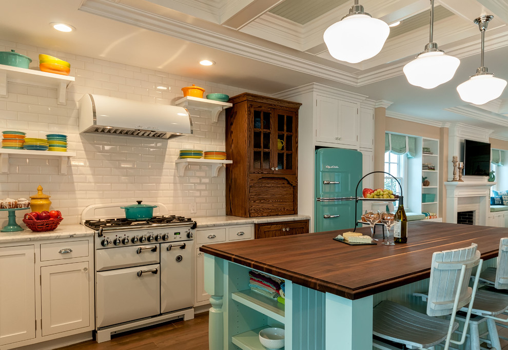 Mid-sized elegant ceramic tile eat-in kitchen photo in San Diego with white cabinets, white backsplash, glass tile backsplash, colored appliances, an island and a farmhouse sink