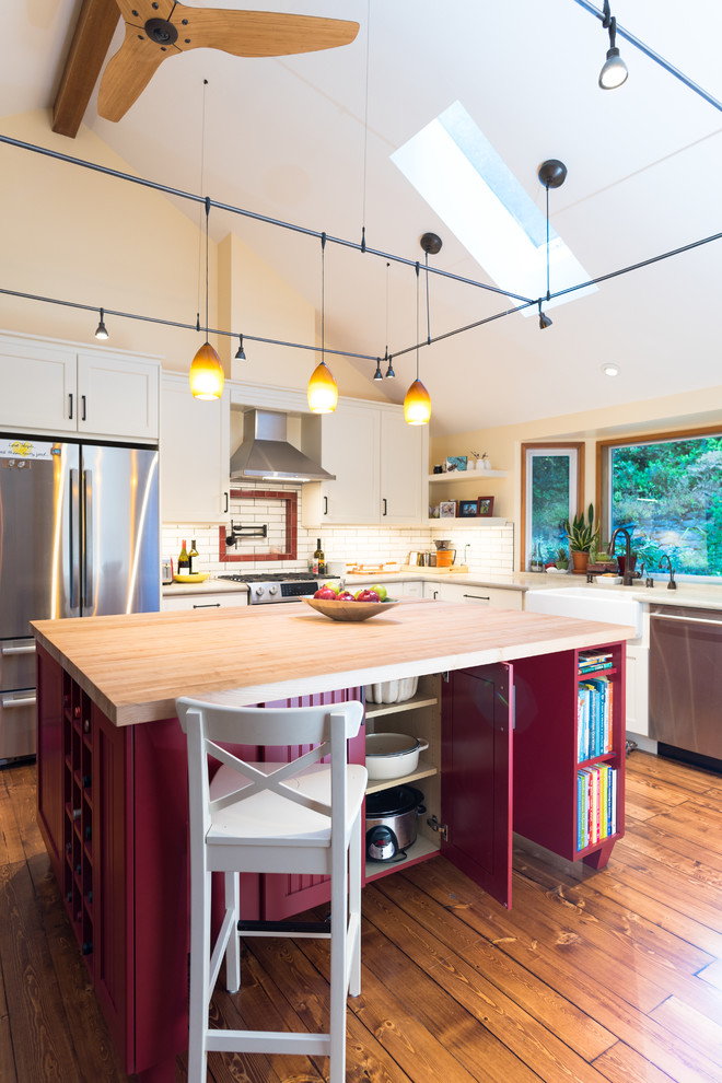 Bild på ett mellanstort lantligt beige beige kök, med en rustik diskho, luckor med infälld panel, vita skåp, bänkskiva i koppar, vitt stänkskydd, stänkskydd i keramik, rostfria vitvaror, en köksö, brunt golv och mellanmörkt trägolv