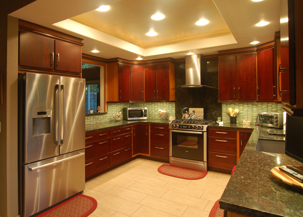サンルイスオビスポにある中くらいなアジアンスタイルのおしゃれなキッチン (シングルシンク、フラットパネル扉のキャビネット、赤いキャビネット、御影石カウンター、緑のキッチンパネル、ガラスタイルのキッチンパネル、シルバーの調理設備、磁器タイルの床、ベージュの床、緑のキッチンカウンター、折り上げ天井) の写真