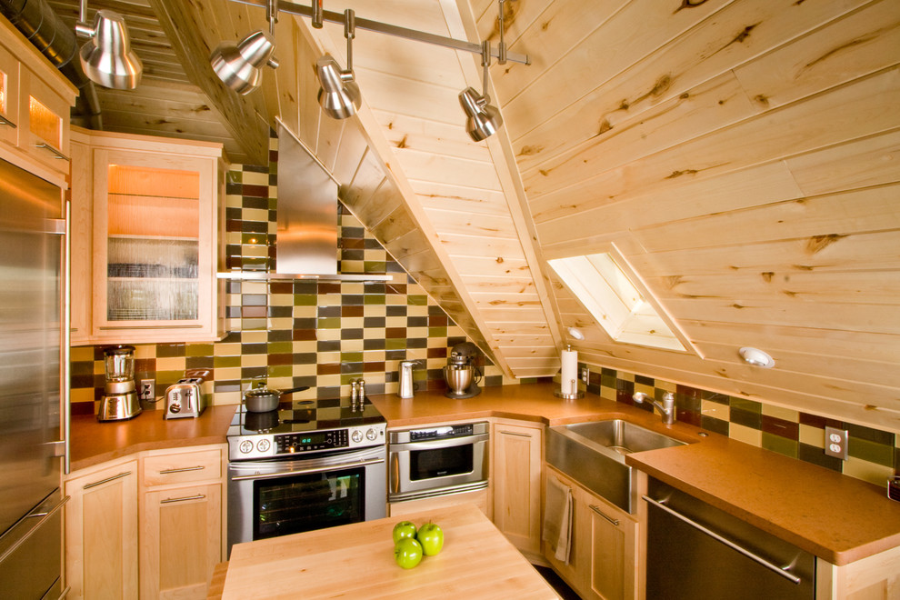 Aménagement d'une cuisine montagne en U et bois clair avec un placard à porte vitrée, un électroménager en acier inoxydable, un évier de ferme et une crédence multicolore.