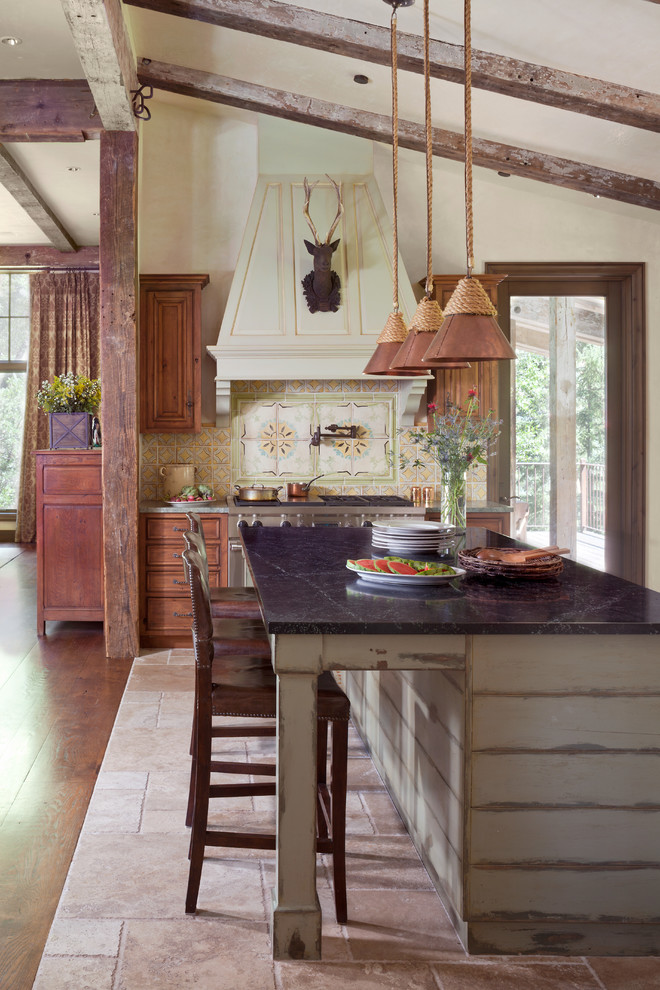 Mountain style l-shaped kitchen photo in Other with medium tone wood cabinets, multicolored backsplash, stainless steel appliances and an island