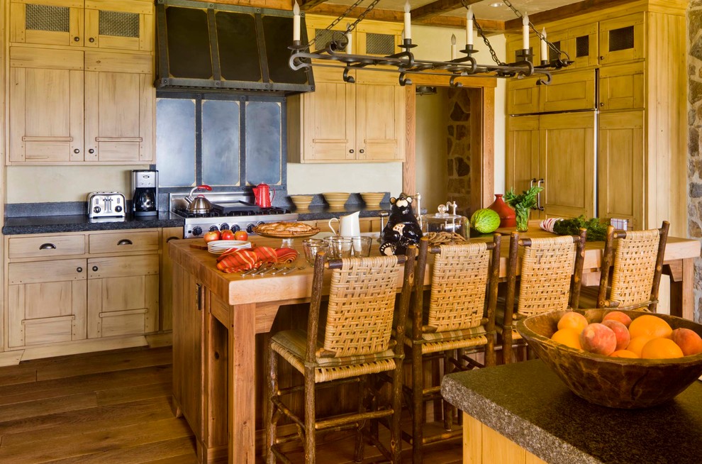 Urige Küche mit Schrankfronten mit vertiefter Füllung, hellbraunen Holzschränken, Küchengeräten aus Edelstahl, braunem Holzboden, zwei Kücheninseln und Mauersteinen in New York
