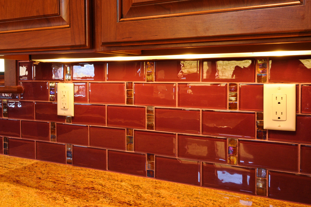 Inspiration pour une grande cuisine américaine chalet avec un plan de travail en granite, une crédence rouge et une crédence en carreau de verre.