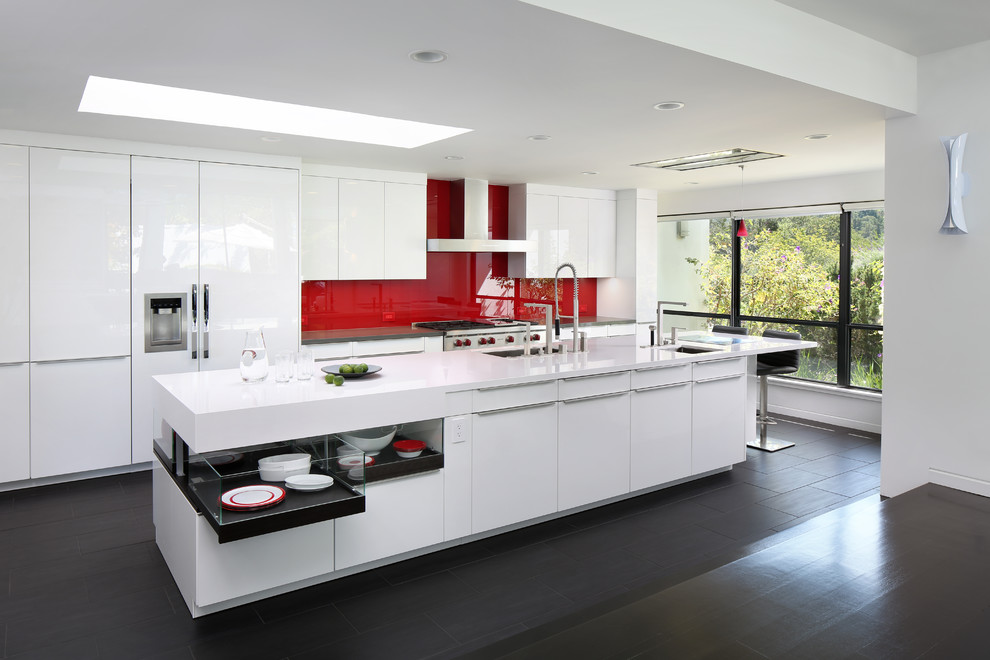 Zweizeilige Moderne Küche mit Unterbauwaschbecken, flächenbündigen Schrankfronten, weißen Schränken, Küchenrückwand in Rot, Glasrückwand, dunklem Holzboden, Kücheninsel und schwarzem Boden in San Francisco
