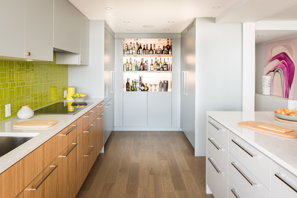 Cette image montre une cuisine design avec une crédence verte et un placard à porte plane.