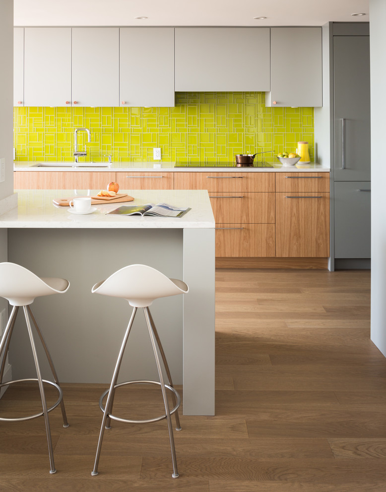 バンクーバーにある高級な中くらいなコンテンポラリースタイルのおしゃれなキッチン (フラットパネル扉のキャビネット、グレーのキャビネット、緑のキッチンパネル) の写真