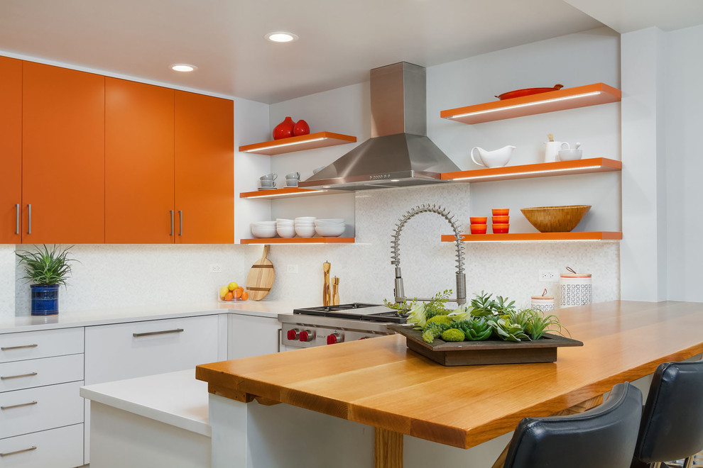 Moderne Küchenbar in U-Form mit flächenbündigen Schrankfronten, orangefarbenen Schränken, Arbeitsplatte aus Holz, Küchenrückwand in Weiß, Küchengeräten aus Edelstahl und Halbinsel in Chicago