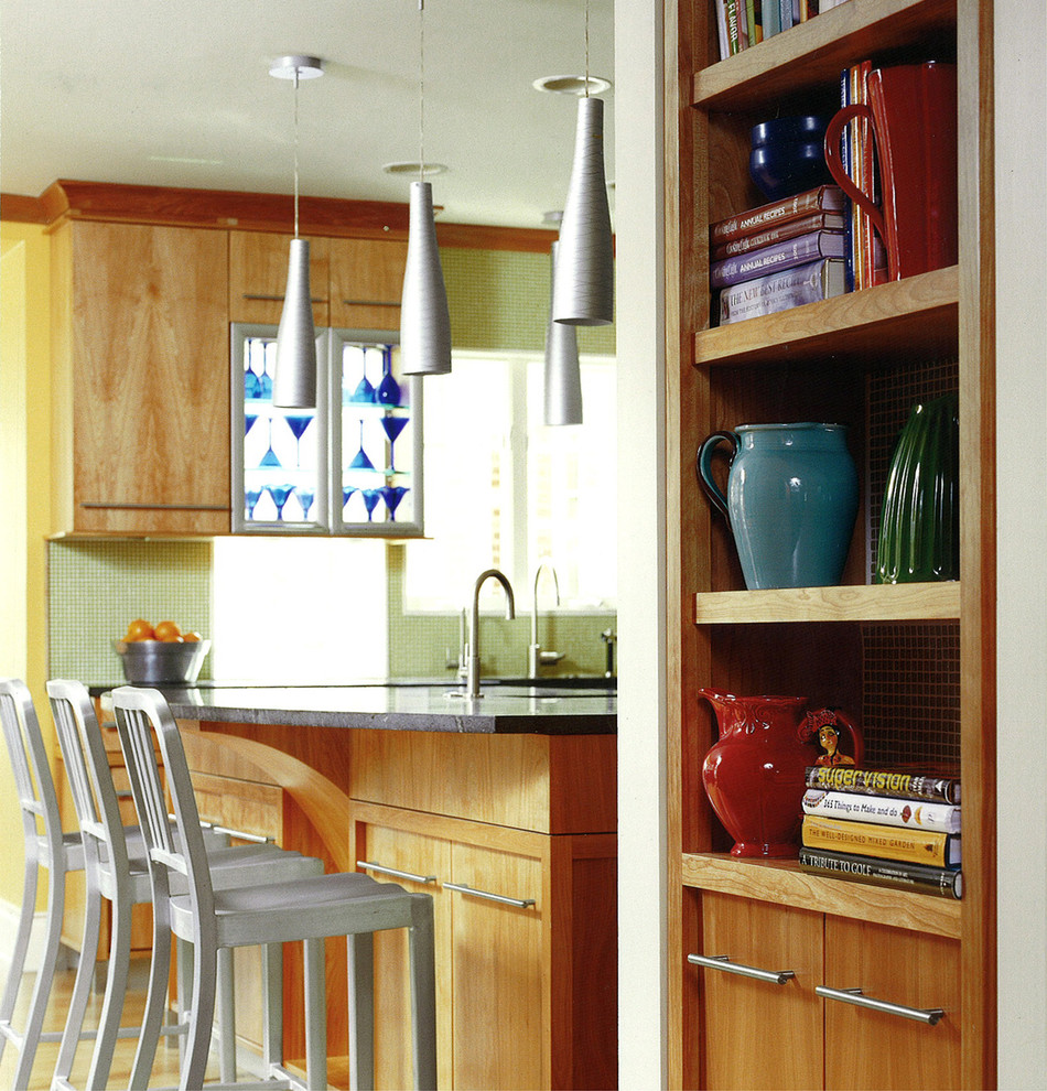 На фото: кухня в стиле фьюжн с плоскими фасадами, светлыми деревянными фасадами, зеленым фартуком, фартуком из плитки мозаики и барной стойкой