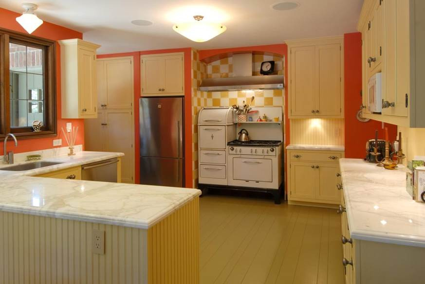 Bild på ett avskilt, mellanstort eklektiskt l-kök, med en undermonterad diskho, skåp i shakerstil, gula skåp, marmorbänkskiva, gult stänkskydd, stänkskydd i trä, rostfria vitvaror, målat trägolv, en halv köksö och beiget golv