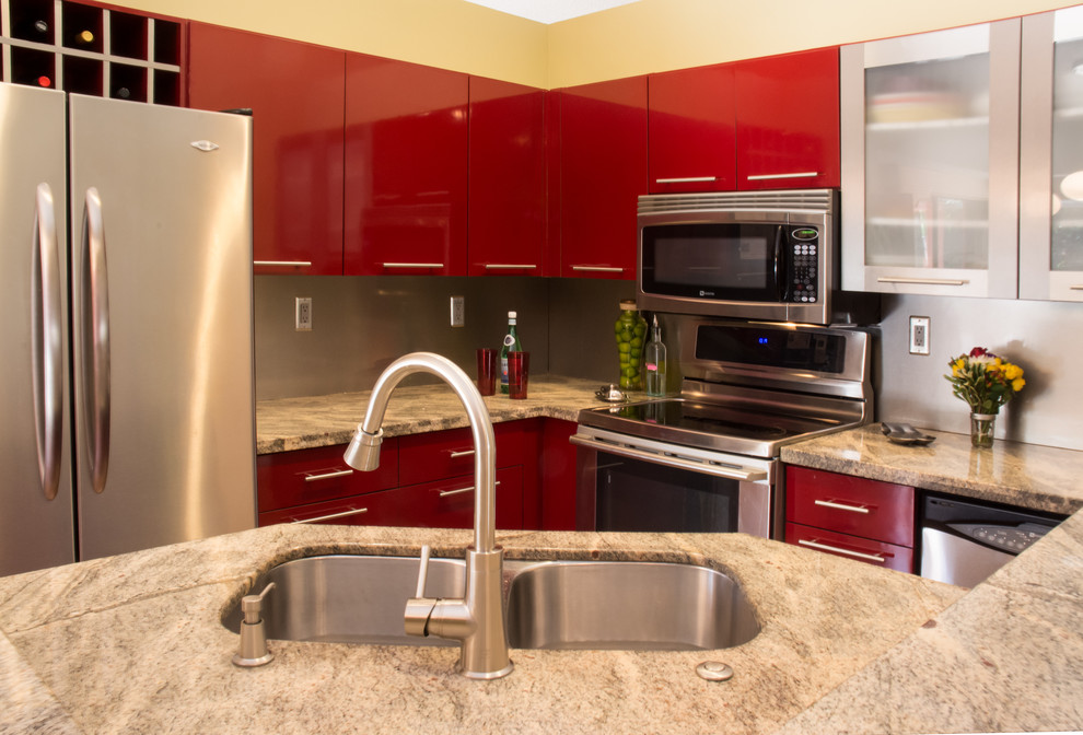 Idéer för ett modernt kök, med en undermonterad diskho, släta luckor, röda skåp, granitbänkskiva, stänkskydd med metallisk yta, stänkskydd i metallkakel och rostfria vitvaror