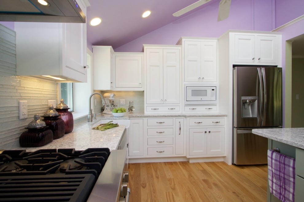 Exempel på ett mellanstort lantligt kök, med en rustik diskho, skåp i shakerstil, vita skåp, granitbänkskiva, grönt stänkskydd, stänkskydd i glaskakel, rostfria vitvaror, ljust trägolv och en halv köksö