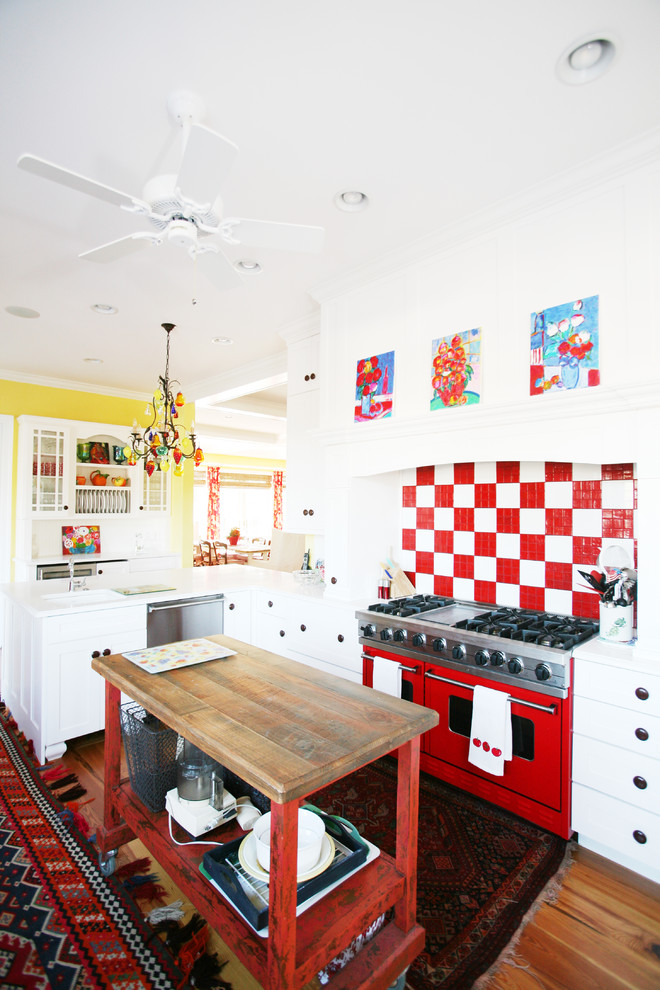 Inspiration för ett eklektiskt kök, med vita skåp, rött stänkskydd och färgglada vitvaror