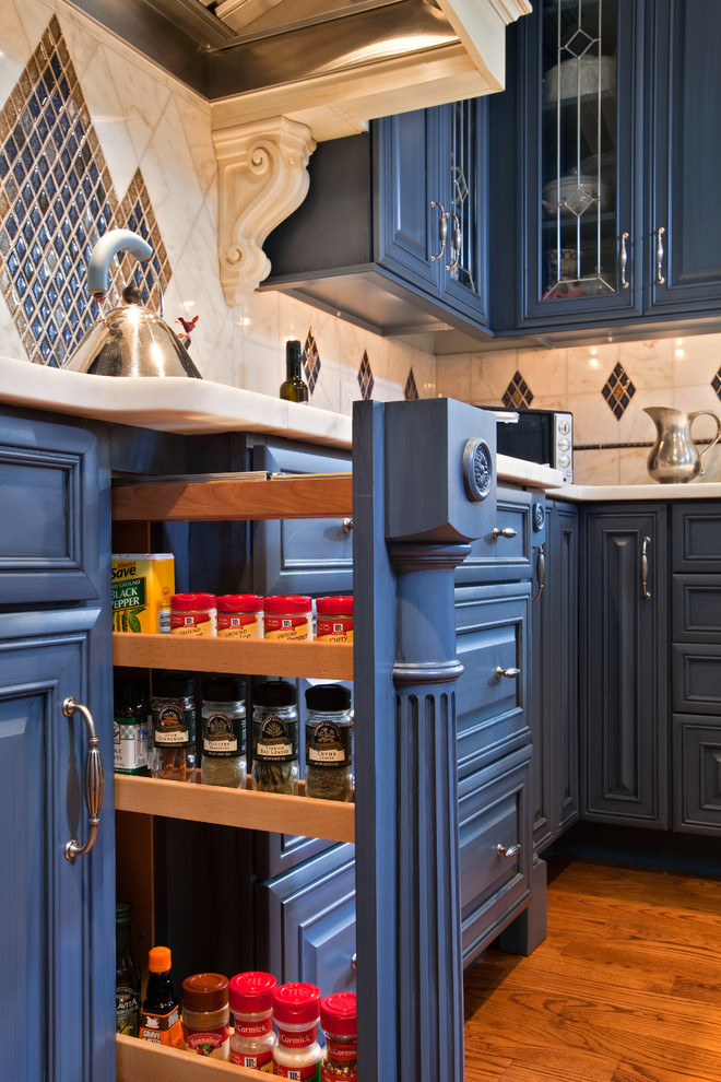 Example of a large eclectic l-shaped medium tone wood floor eat-in kitchen design in Boston with raised-panel cabinets, blue cabinets, marble countertops, multicolored backsplash, mosaic tile backsplash, stainless steel appliances and an island