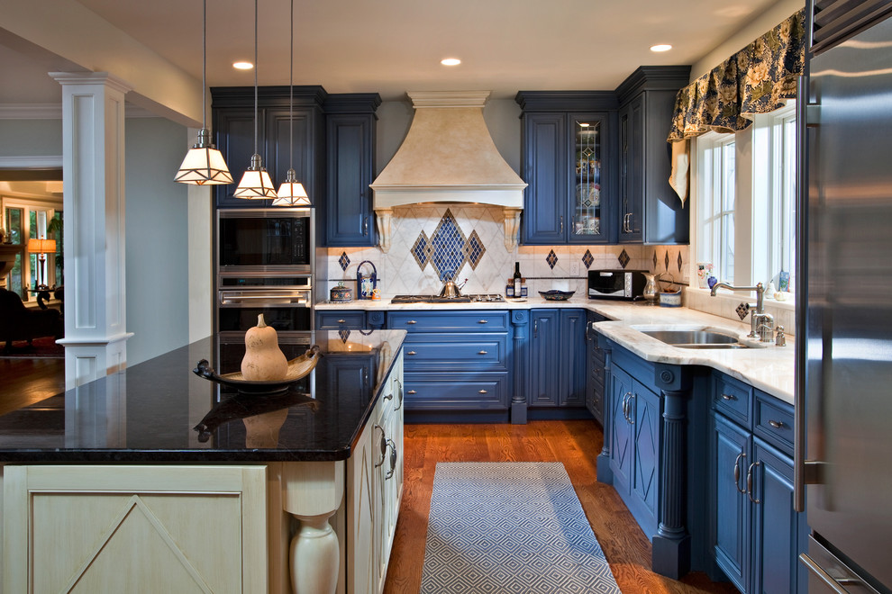 Large eclectic l-shaped medium tone wood floor eat-in kitchen photo in Boston with a double-bowl sink, raised-panel cabinets, blue cabinets, marble countertops, multicolored backsplash, mosaic tile backsplash, stainless steel appliances and an island