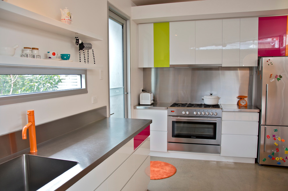 Foto de cocina ecléctica con electrodomésticos de acero inoxidable, encimera de acero inoxidable y fregadero integrado