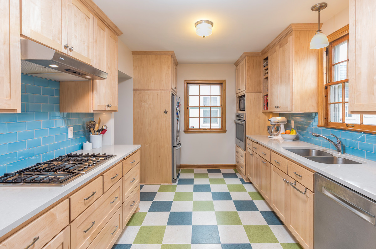 Kitchen - contemporary galley multicolored floor kitchen idea in Minneapolis with an undermount sink, flat-panel cabinets, light wood cabinets, blue backsplash, subway tile backsplash and stainless steel appliances