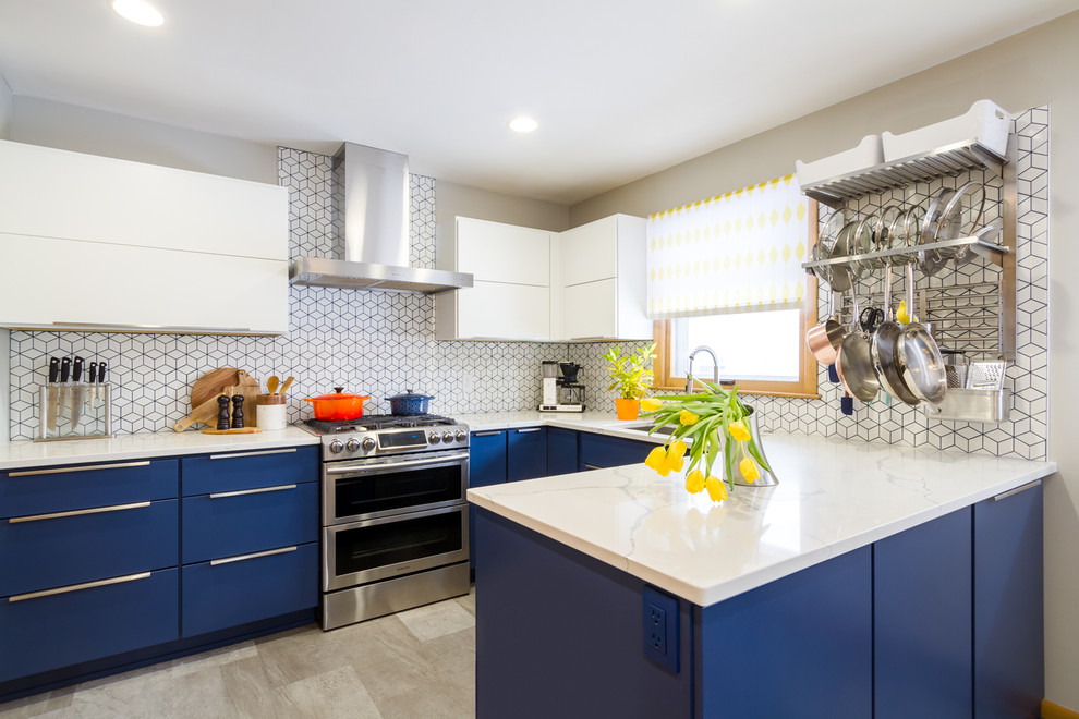 Foto på ett avskilt, mellanstort 50 tals vit u-kök, med en undermonterad diskho, släta luckor, blå skåp, bänkskiva i kvarts, vitt stänkskydd, stänkskydd i keramik, rostfria vitvaror, cementgolv, en halv köksö och grått golv