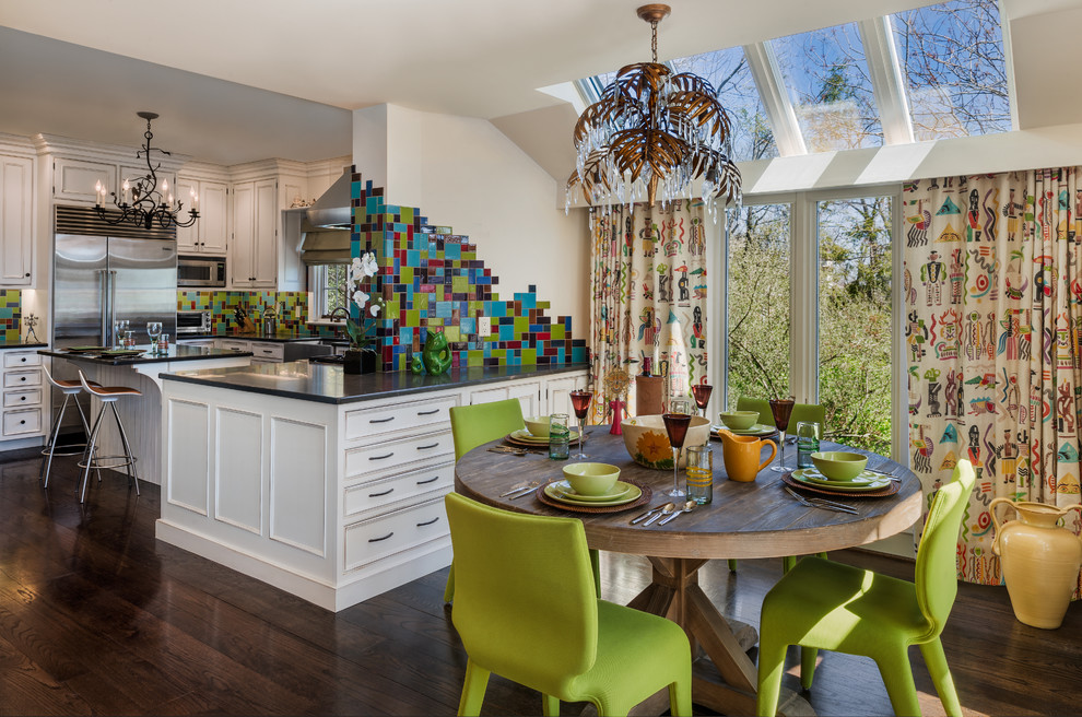 Example of an eclectic u-shaped dark wood floor eat-in kitchen design in Philadelphia with beaded inset cabinets, white cabinets, granite countertops, multicolored backsplash, glass tile backsplash, stainless steel appliances, an island and a farmhouse sink
