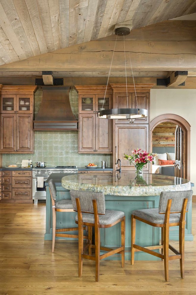 Foto på ett stort rustikt svart kök, med en enkel diskho, luckor med upphöjd panel, granitbänkskiva, grönt stänkskydd, stänkskydd i keramik, integrerade vitvaror, mellanmörkt trägolv, en köksö, brunt golv och skåp i mellenmörkt trä