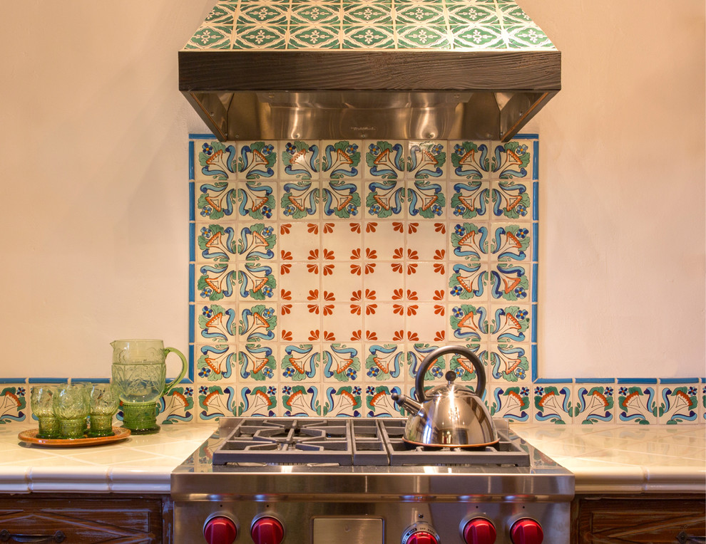 Exempel på ett avskilt, litet amerikanskt l-kök, med en rustik diskho, luckor med upphöjd panel, beige skåp, kaklad bänkskiva, flerfärgad stänkskydd, stänkskydd i terrakottakakel, rostfria vitvaror och en köksö