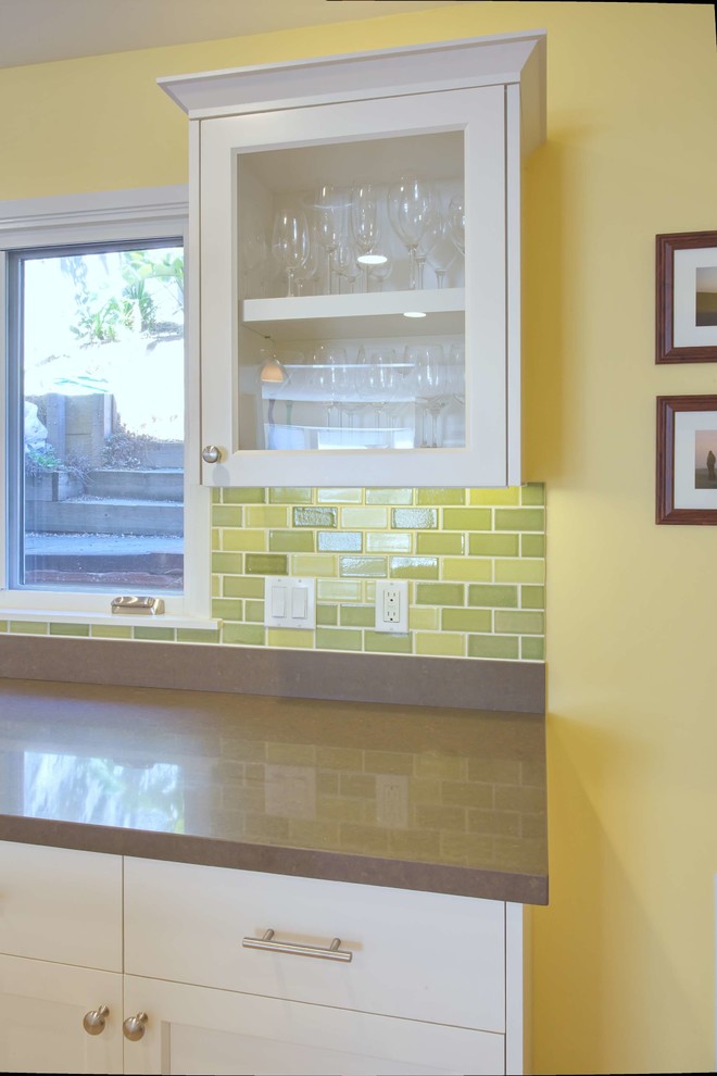 Foto på ett stort funkis kök, med en undermonterad diskho, släta luckor, vita skåp, bänkskiva i kvarts, grönt stänkskydd, stänkskydd i keramik, rostfria vitvaror, ljust trägolv, en köksö och beiget golv