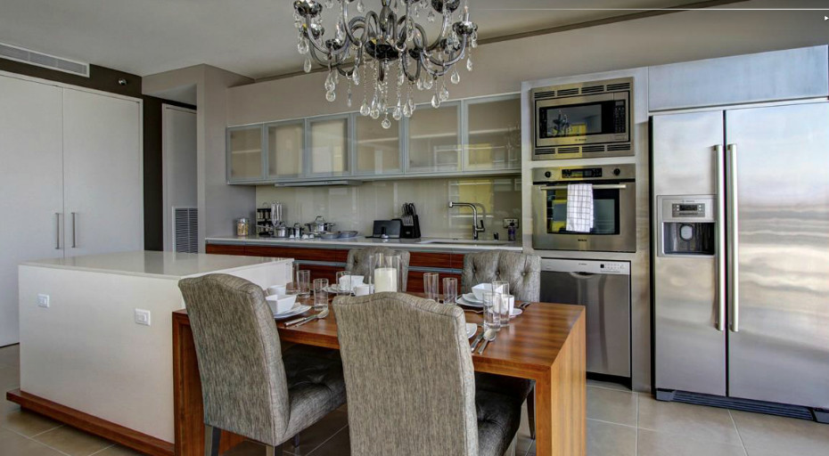 Esempio di una cucina minimalista di medie dimensioni con lavello sottopiano, elettrodomestici in acciaio inossidabile, paraspruzzi con piastrelle di vetro e parquet chiaro