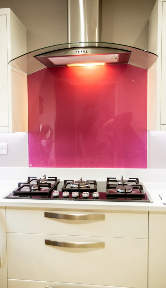 Modelo de cocina minimalista con salpicadero rosa y salpicadero de vidrio templado